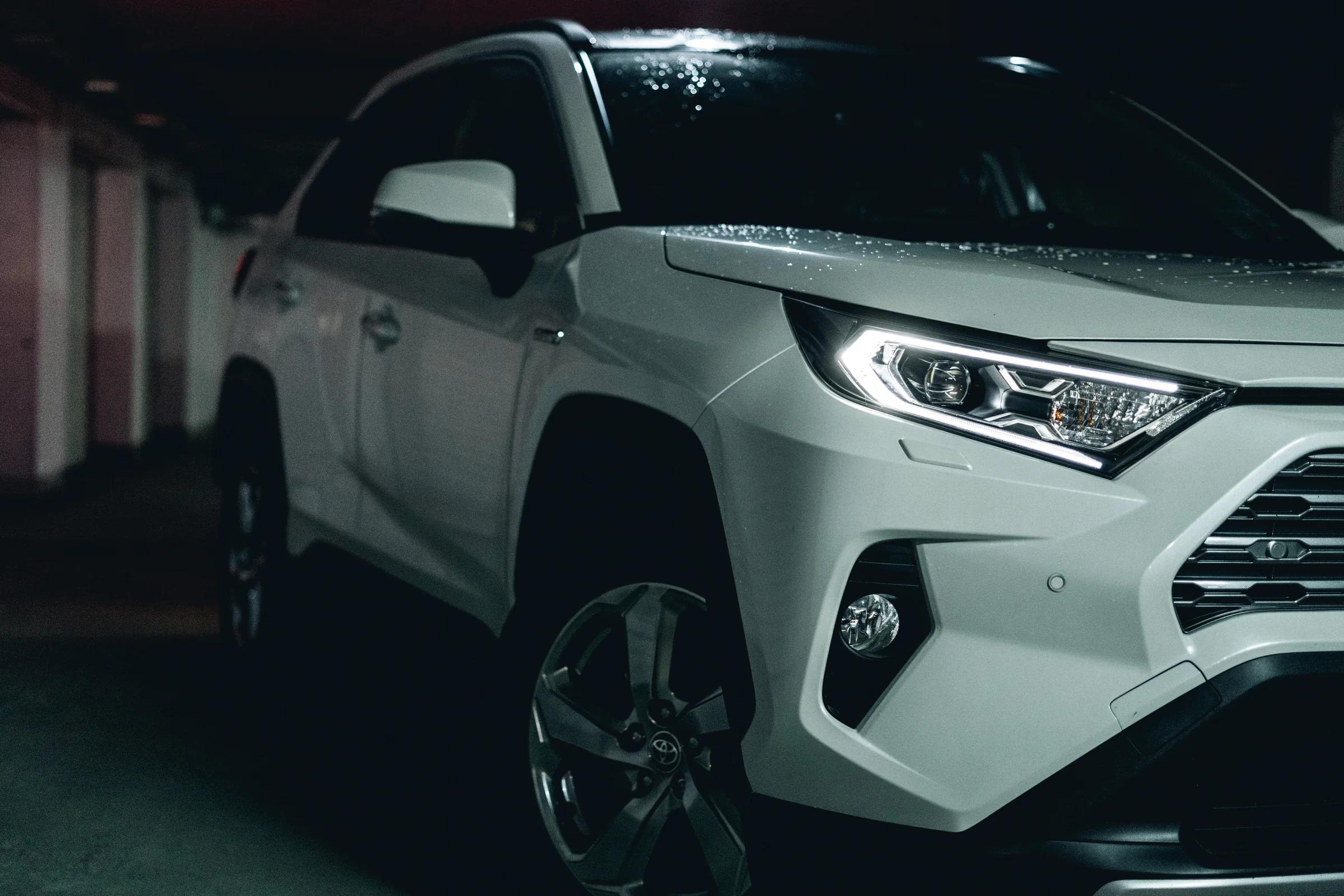 White Toyota RAV4 in a low-lit underground car park